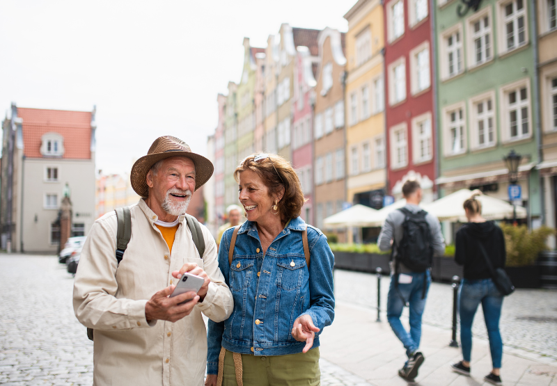 couple in their 60s walking the streets of a city in Europe.