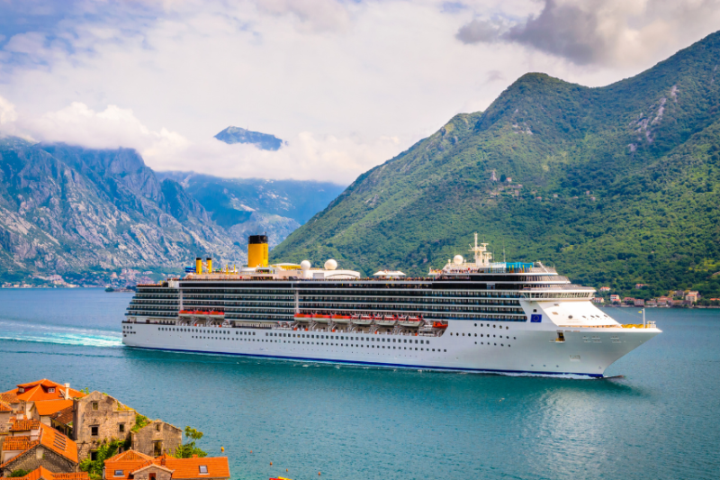 cruise ship on water near mountains