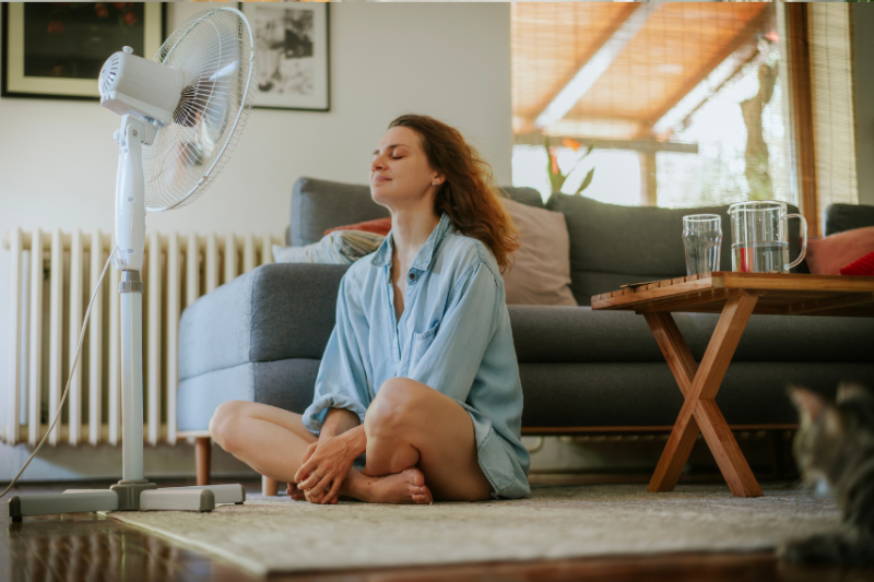 Woman cools down in front of a fan