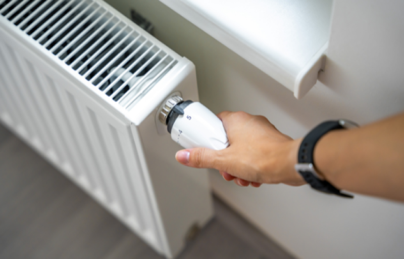 person changing radiator temperature