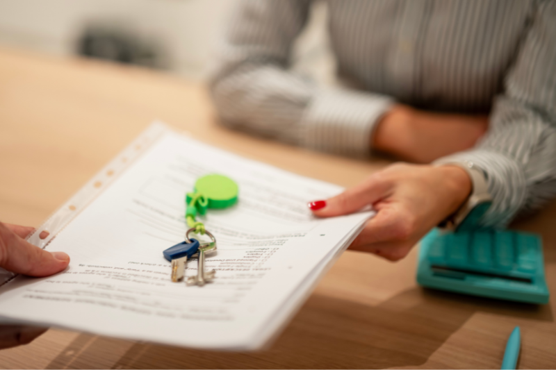 person handing over tenancy agreement with keys