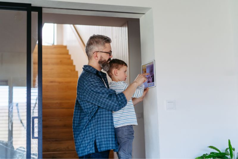 father showing son touchscreen at home
