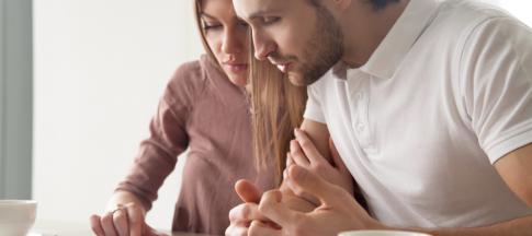 couple-sat-at-a-table-looking-at-loan-documents