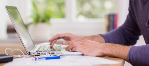 bearded-man-working-from-home-at-his-laptop