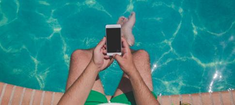 Man sitting by the tool with a mobile phone