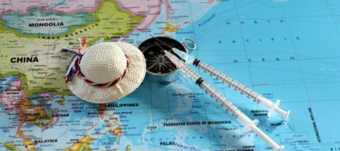 Two travel vaccination syringes on top of a world map