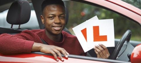 teenage-boy-in-car-holding-l-plates