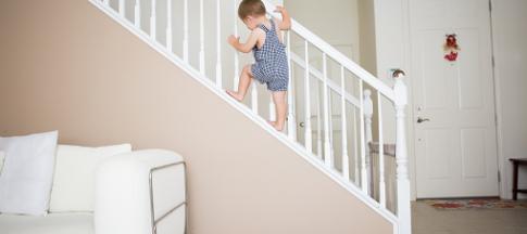 Child climbing up a banister