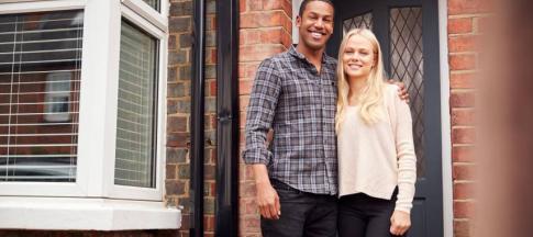 Image of a couple outside a house.