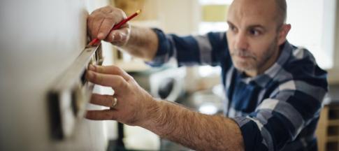 Image of man using a spirit level to put up a shelf