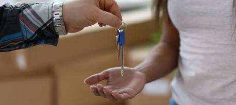Image of tenants receiving keys to their property.
