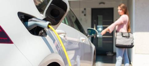 Image of woman charging her electric car. 