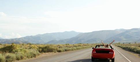 Image of a couple driving a sportscar