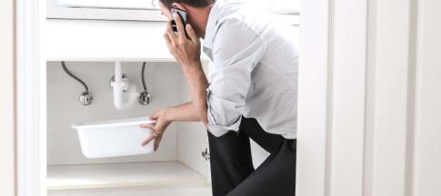 Image of a white man calling for help after spotting a house leak