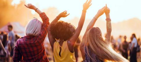 Three women at a festival dancing