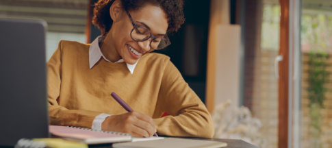 Woman with glasses making notes on paper