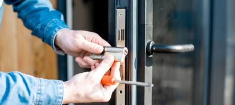 A man fitting a lock on a door