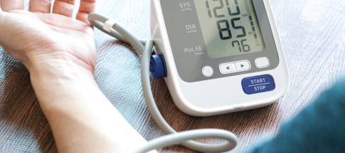 person having blood pressure taken with device