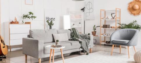 A living room with sofa, chair, coffee table and bookshelves