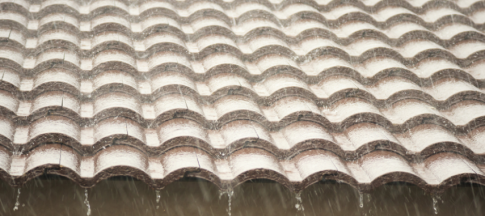 heavy rain falling on roof of house