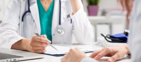 A doctor with a clipboard, speaking to a patient