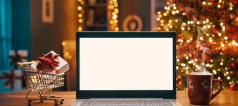 laptop open on desk with christmas decorations behind