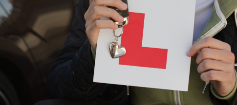 person holding learner sticker and keys