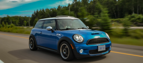 blue mini cooper driving on country road