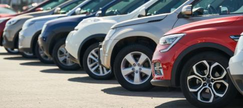 A line of cars next to each other, one red one at the forefront