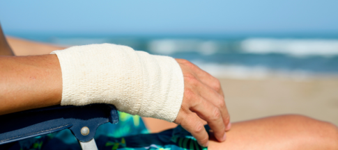 person with bandaged arm on beach