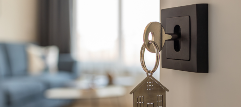 image of key in door with house keyring attached