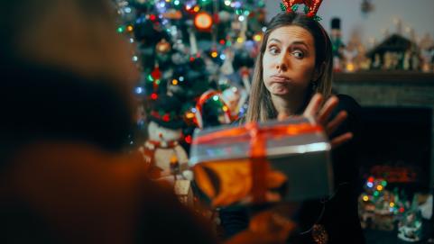 Ungrateful Woman Refusing a Christmas Gift from a Friend. Rude holiday party host rejecting presents from her guests