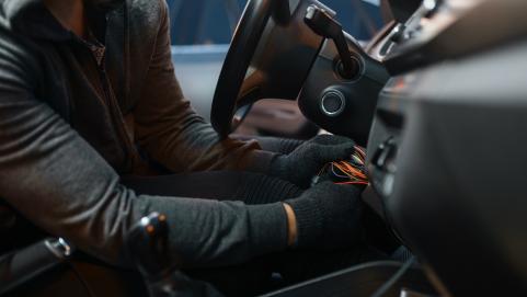 Professional car thief hacking ignition lock steering wheel