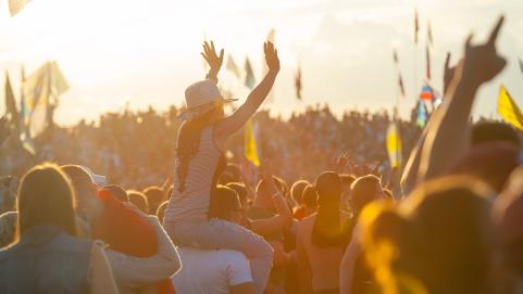 Festival crowd woman on man's shoulders in crowd